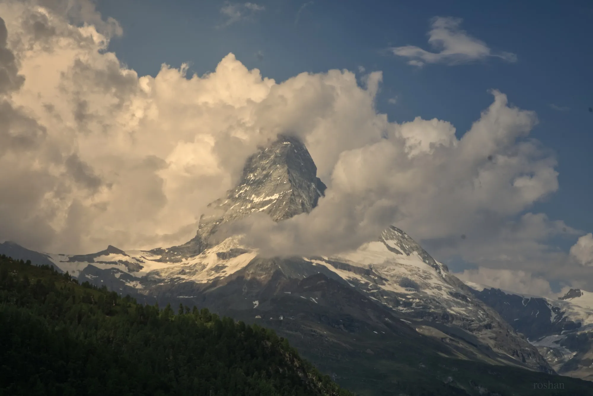 The Matterhorn peak emerging from dramatic golden-tinted clouds.